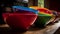 Vibrant colored crockery stack on wooden table generated by AI