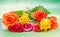 Vibrant colored (red, yellow, orange, white) roses flowers, close up, bouquet, floral arrangement, green background