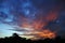 The Vibrant colors of clouds and silhouette of trees and a church.