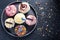 Vibrant cupcakes on plate on dark background