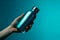 Vibrant cyan backdrop highlights female hand gripping steel water bottle