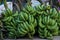 Vibrant display of fresh, unripe bananas neatly arranged on a countertop at a local grocery store