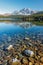 Vibrant early autumn high tatra lake view with mountains, pine forest, sky reflection for hiking