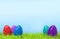 Vibrant Easter Colorful Eggs in Lush Green Grass - Blue Sky Background - 3D Illustration