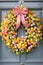 Vibrant easter wreath adorned with colorful eggs hanging on house door