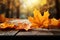 Vibrant fall leaves rest on a rustic wooden table, autumn themed