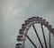 Vibrant Ferris wheel against a cloudy sky backdrop.