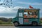 A vibrant food truck parked alongside the road, offering a wide variety of delicious and convenient food options, A food truck