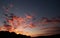 Vibrant, glowing, cloud filled sunrise coming up over a silhouette foreground