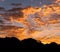 Vibrant, glowing, cloud filled sunrise coming up over a silhouette foreground