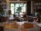 Vibrant green bonsai tree in a terracotta pot atop a wooden dining table