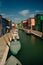 Vibrant houses along a boat lined canal in Burano, Venice, Italy - nov, 2021