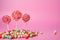 Vibrant lollipops and confections adorn a pretty pink background