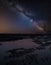 Vibrant Milky Way composite image over landscape of low tide on