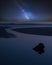 Vibrant Milky Way composite image over landscape of low tide beach