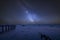 Vibrant Milky Way composite image over landscape of low tide harbour with jetty