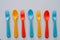 Vibrant multicolored forks, kives and spoons white background