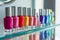 vibrant nail polish bottles in a row on glass shelf