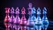 Vibrant neon chess pieces on dark background with chessboard, creating a captivating scene