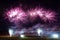 Vibrant night sky illuminated by an array of colorful fireworks bursting above a lake