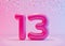 Vibrant number thirteen with colorful confetti on pink background. Symbol 13. Invitation for a thirteenth birthday party