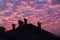 Vibrant orange clouds over rooftop chimneys