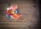 Vibrant overhead photo of orange and yellow lilies in a blue glass vase on a rustic pine table