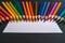 Vibrant palette Multi colored pencils and white paper on elegant black backdrop