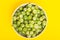 Vibrant photo of fresh gooseberry in a plate on yellow background