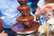 Vibrant Picture of Chocolate Fountain Fontain on childen kids birthday party with a kids playing around and marshmallows and fruit