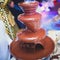 Vibrant Picture of Chocolate Fountain Fontain on childen kids birthday party with a kids playing around and marshmallows and fruit