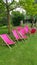 Vibrant pink deckchairs on emerald green lawn