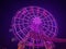 Vibrant purple Ferris wheel illuminated by lights in a bustling fairground