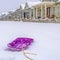 Vibrant purple sled with snow and homes background