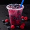 Vibrant purple slushie in a clear plastic cup with fresh berry garnish