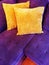 Vibrant purple sofa with orange cushions