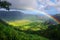 A vibrant rainbow arches across the sky, with a backdrop of a flourishing green valley beneath, A rainbow spanning across a lush