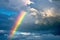 A vibrant rainbow stretches across a cloudy sky, adding a burst of color to the atmosphere, A rainbow emerging from storm clouds,