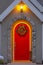 Vibrant red arched front door with colorful wreath