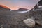 Vibrant red colored mountains by sunset in a glacier valley