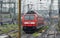 Vibrant red passenger train traveling along a scenic railway route in Germany.