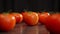 Vibrant red tomatoes on wooden table, showcasing natural texture and color