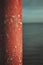 Vibrant scene of a weathered red pole standing in the foreground of a tranquil body of water