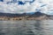 Vibrant scenery and deep-blue waters of the Tenerife west coastline as seen from a yacht. The dormant Teide volcano can be seen in