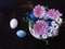 Vibrant still life of a bowl of eggs surrounded by an array of colorful flowers.