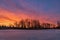 Vibrant Sunrise Glowing Over A Frozen Park Lake