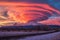 vibrant sunset colors illuminating lenticular clouds over mountains