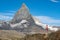 Vibrant Swiss flag waving against a backdrop of majestic rocky Matterhorn mountain