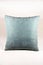 Vibrant teal pillow on a white velvet background