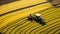 Vibrant Tractor Driving In Yellow Rice Field - Aerial Photography